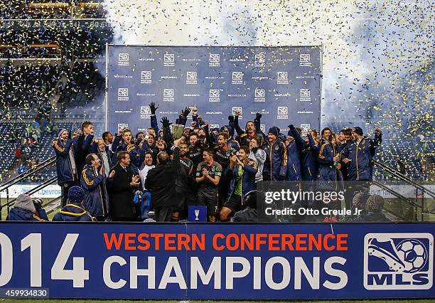 Head coach Bruce Arena of the Los Angeles Galaxy hoists the Western Conference trophy after the Galaxy advanced to the MLS cup against the Seattle...