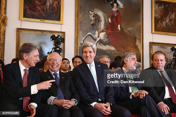 Secretary of State John Kerry and Abdullah Abdullah, Chief Executive Officer of Afghanistan wait for a speech by British Prime Minister David Cameron...