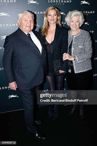 Model Kate Moss standing between owners of Longchamp Michele and Philippe Cassegrain attend the Longchamp Elysees "Lights On Party" Boutique Launch...