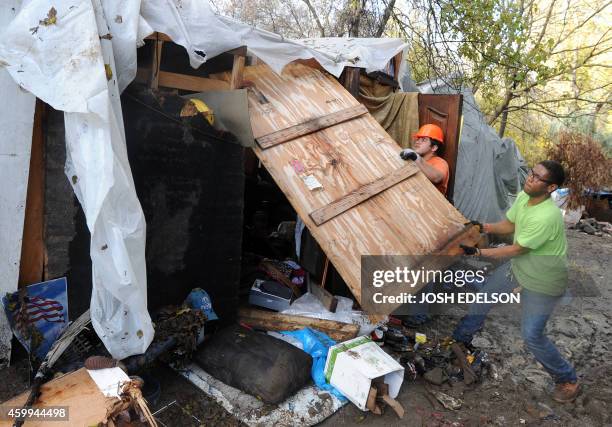 Workers dismantle a dwelling at a Silicon Valley homeless encampment known as The Jungle on December 4 in San Jose, California. Authorities began...