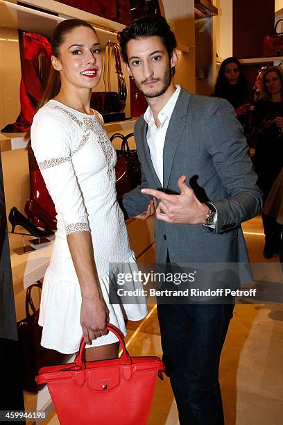 Actors Pierre Niney and his Fiance Natasha Andrews attend the Longchamp Elysees "Lights On Party" Boutique Launch on December 4, 2014 in Paris,...
