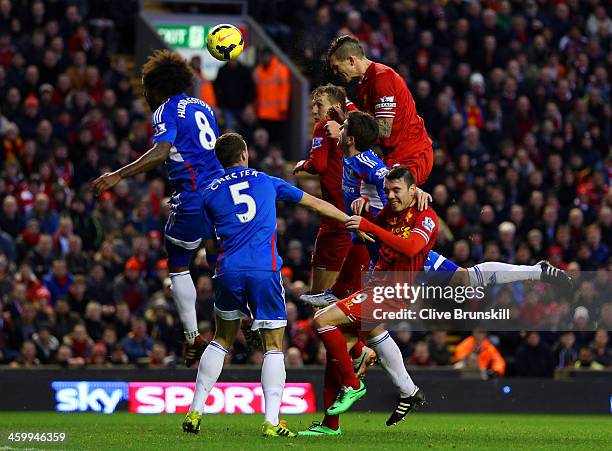 Daniel Agger of Liverpool heads in their first goal past Tom Huddlestone of Hull City during the Barclays Premier League match between Liverpool and...