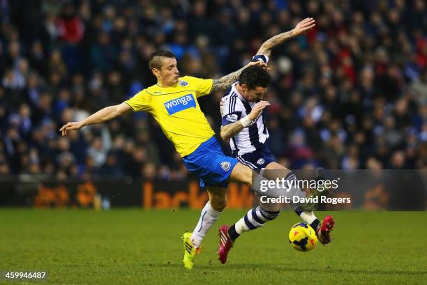 Mathieu Debuchy of Newcastle United tackles Liam Ridgewell of West Bromwich Albion during the Barclays Premier League match between West Bromwich...