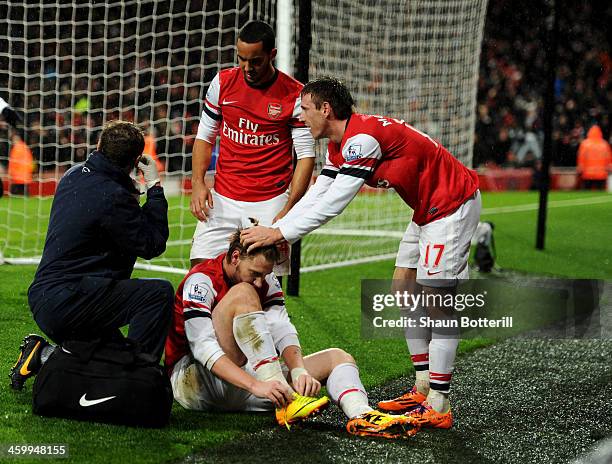 An injured Nicklas Bendtner of Arsenal is congratulated by team mates Theo Walcott and Nacho Monreal as he scores their first goal during the...