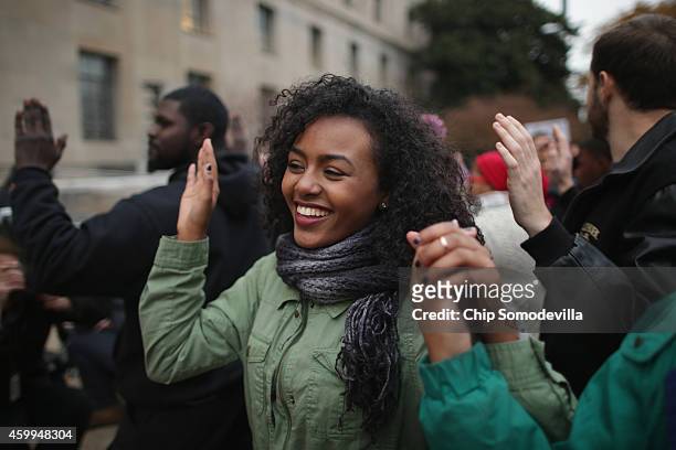 Demonstrators march in front of the Justice Department headquarters chanting "Hands up! Don't shoot!" and "I can't breath!" in protest against recent...