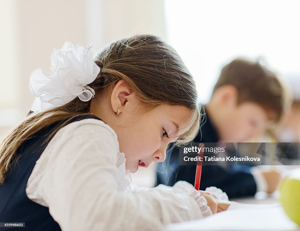 Children writing drawing in class