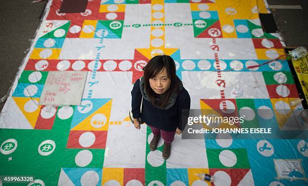 In this picture taken on December 4 artist Helen Fan, one of the founders of the online glossary Umbrella Terms, stands on a giant chess game at the...