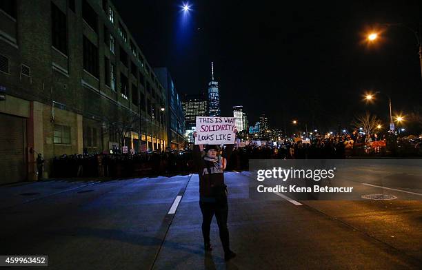 Demonstrator holds a banner a the West St Hight way while Police block the street, during a protest following yesterday's decision by a Staten Island...