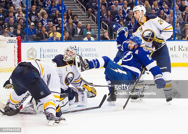 Ryan Callahan of the Tampa Bay Lightning is checked by Tyson Strachan and his skate hits goalie Jhonas Enroth of the Buffalo Sabres in the mask...