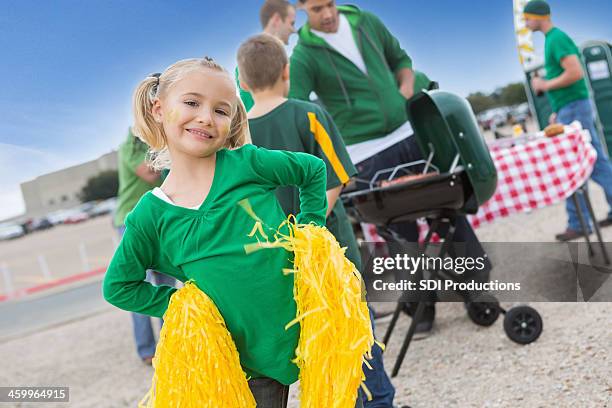 cute little girl cheering for football team at tailgating party - college football cheerleaders 個照片及圖片檔