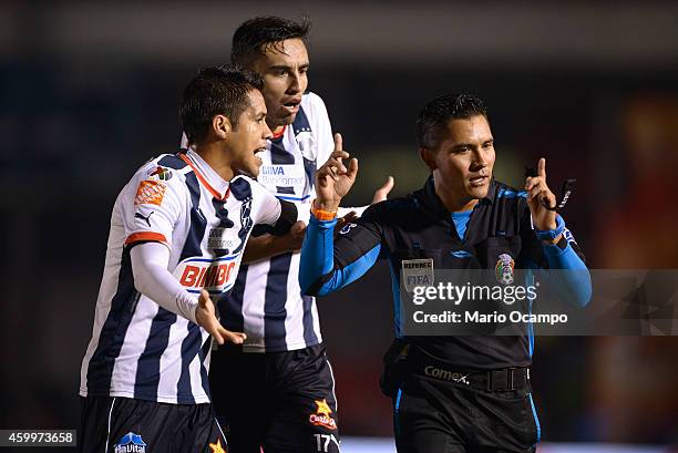 Severo Meza and Jesus Zavala of Monterrey argue with referee Fernando Guerrero during a semifinal first leg match between Monterrey and America as...