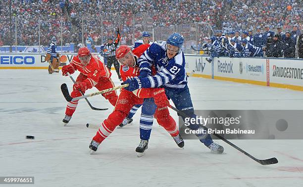 James van Riemsdyk of the Toronto Maple Leafs shoots the puck as Pavel Datsyuk of the Detroit Red Wings tries to defend the play in the first period...