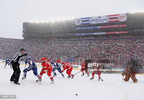 Henrik Zetterberg of the Detroit Red Wings wins a face off against Peter Holland of the Toronto Maple Leafs during the first period of the 2014...