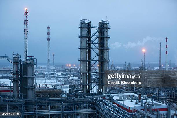 Waste gas flares burn from pipes near petroleum cracking towers, center, at the Lukoil-Nizhegorodnefteorgsintez oil refinery, operated by OAO Lukoil,...