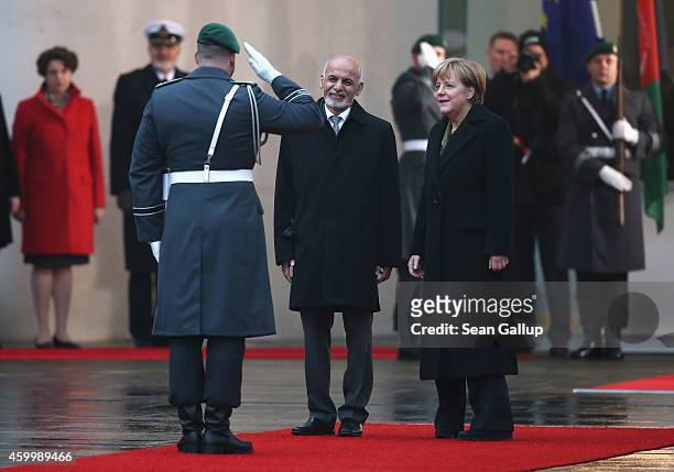 German Chancellor Angela Merkel and Afghan President Ashraf Ghani finish reviewing a guard of honour upon Ghani's arrival at the Chancellery on...