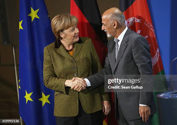 German Chancellor Angela Merkel and Afghan President Ashraf Ghani depart after speaking to the media following talks at the Chancellery on December...