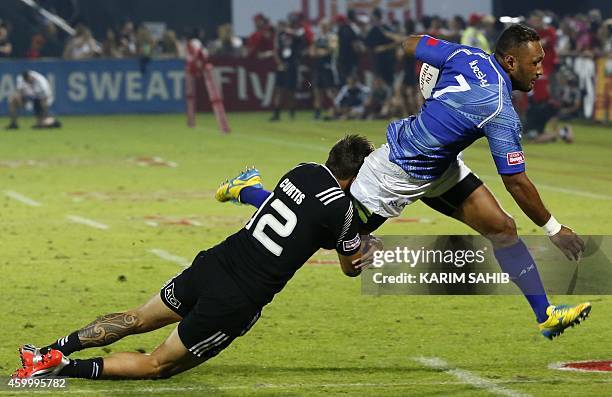 Ambrose Curtis of New Zealand tackles Lolo Lui of Samoa during their rugby match on the first day of the Dubai leg of IRB's Sevens World Series on...