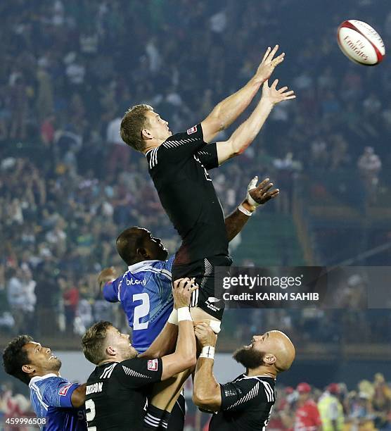 Scott Curry of New Zealand jumps for the ball during his rugby match against Samoa on the first day of the Dubai leg of IRB's Sevens World Series on...