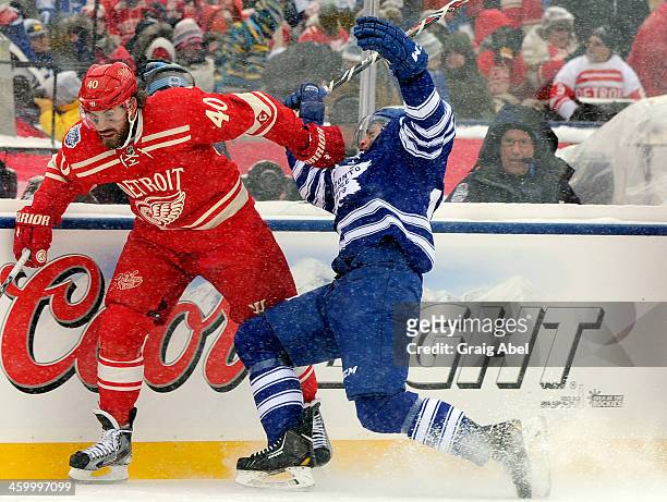 Jerry D'Amigo of the Toronto Maple Leafs runs into Henrik Zetterberg of the Detroit Red Wings during the 2014 Bridgestone NHL Winter Classic January...