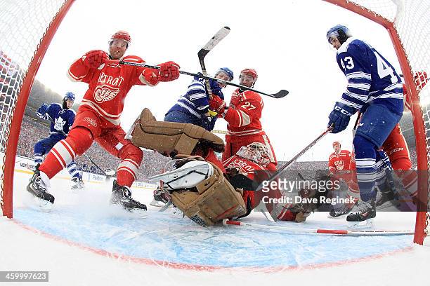 Jimmy Howard of the Detroit Red Wings makes a spinning arm save as teammates Daniel Cleary and Kyle Quincey defend against David Clarkson and Nazem...