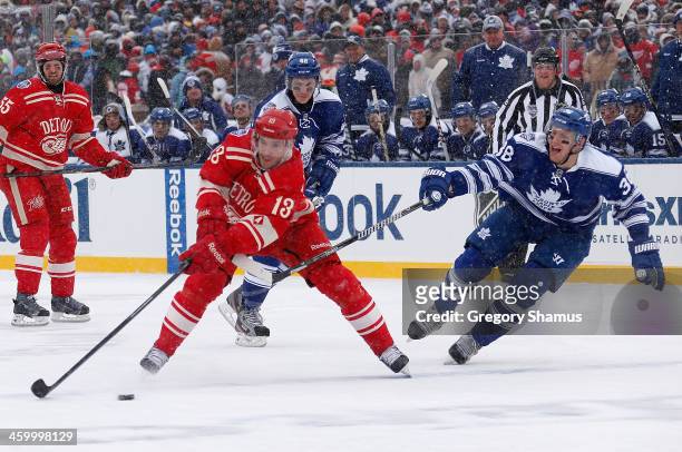 Pavel Datsyuk of the Detroit Red Wings looks to avoid Frazer McLaren of the Toronto Maple Leafs in the second period during the 2014 Bridgestone NHL...