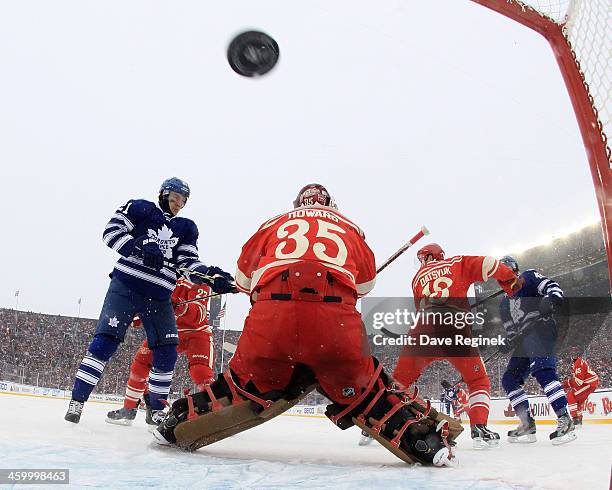 Tyler Bozak of the Toronto Maple Leafs tips in the puck past Jimmy Howard of the Detroit Red Wings to take the lead in the 3rd period of...