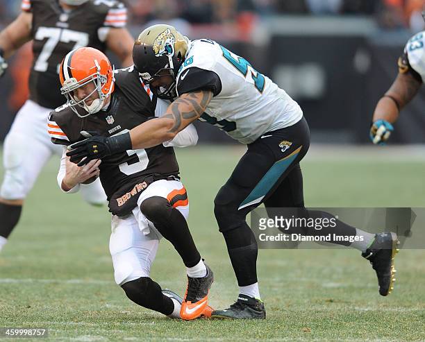 Quarterback Brandon Weeden of the Cleveland Browns is tackled by defensive end Jason Babin of the Jacksonville Jaguars during a game against the...