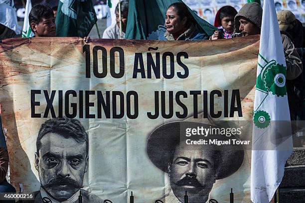Mexican farmers hold a banner with faces of Emiliano Zapata and Pancho Villa during a protest by Agricultural Organizations to demand justice for the...