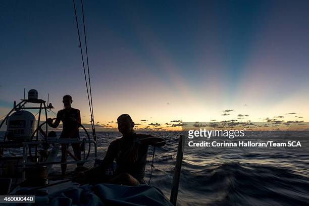 In this handout image provided by the Volvo Ocean Race onboard Team SCA, Sophie Ciszek helms at sunset while Dee Caffari trims the A3. During Leg 2...