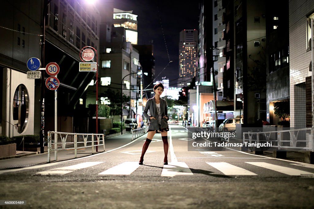 Woman standing on the street at night