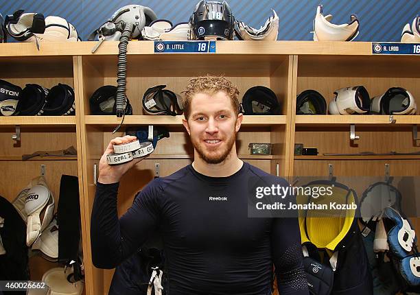 Bryan Little of the Winnipeg Jets displays the three pucks in which he scored the franchise's first hat trick against the Colorado Avalanche on...