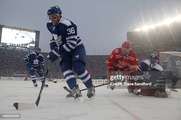 Carl Gunnarsson of the Toronto Maple Leafs controls the puck in the defensive zone while under pressure from Daniel Alfredsson of the Detroit Red...