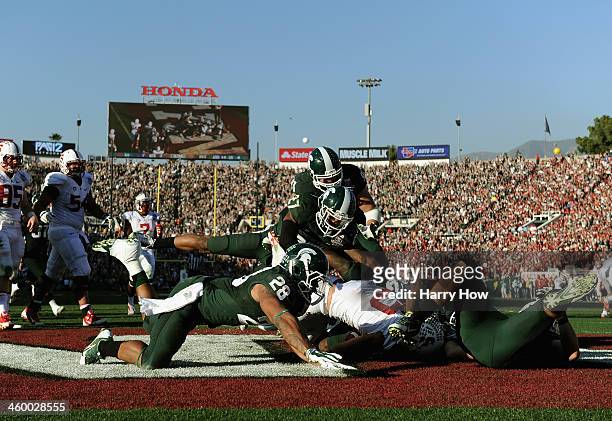 Running back Tyler Gaffney of the Stanford Cardinal is tackled by linebacker Kyler Elsworth of the Michigan State Spartans during the 100th Rose Bowl...