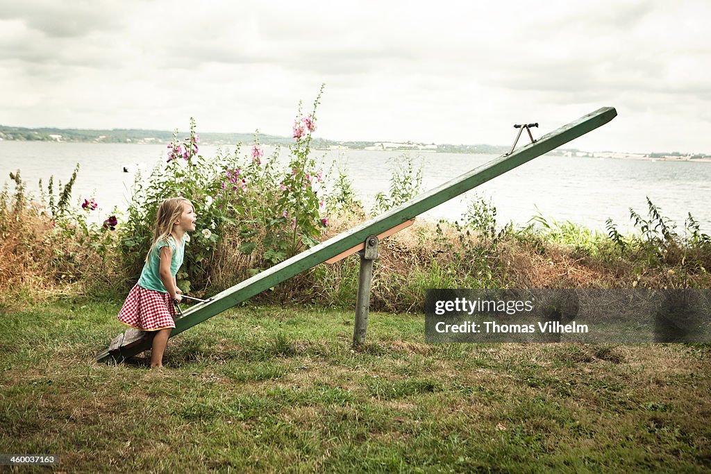 Girl playing on a seesaw