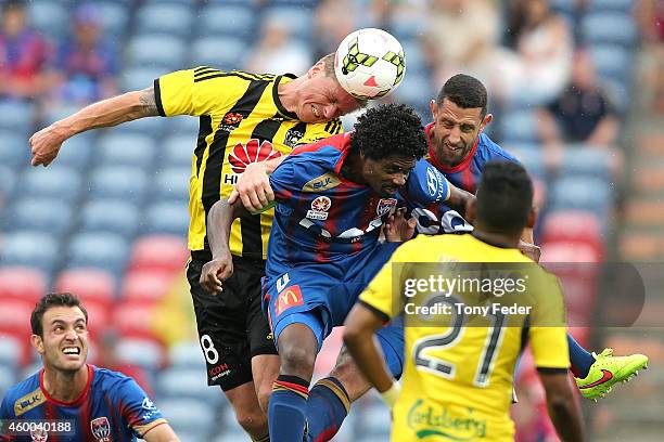 Benjamin Sigmund of the Phoenix heads the ball over Kew Jaliens of the Jets during the round 10 A-League match between the Newcastle Jets and the...