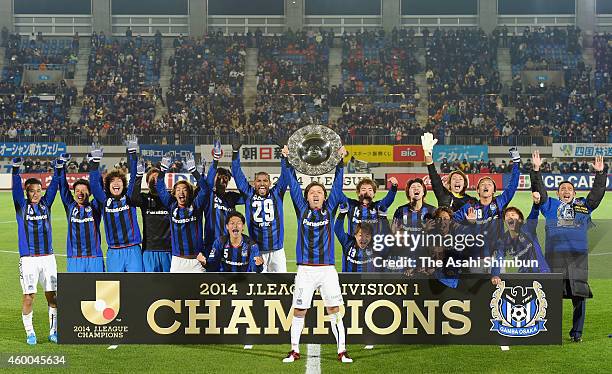 Captain Yasuhito Endo lifts the trophy as they won the 2014 J.League season champion after the 0-0 draw in the J.League match between Tokushima...