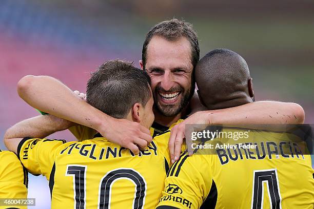 Andrew Durante celebrates a goal with Michael McGlinchey and Rolieny Bonevacia of the Phoenix during the round 10 A-League match between the...