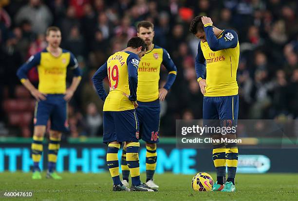 Olivier Giroud and Santi Cazorla of Arsenal look dejected after coneding a third goal during the Barclays Premier League match between Stoke City and...