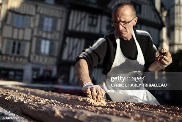 Volunteer puts cream on a traditional Christmas yule log cake during an attempt to set a new Guinness World Record with a 1.5 kilometre yule log cake...