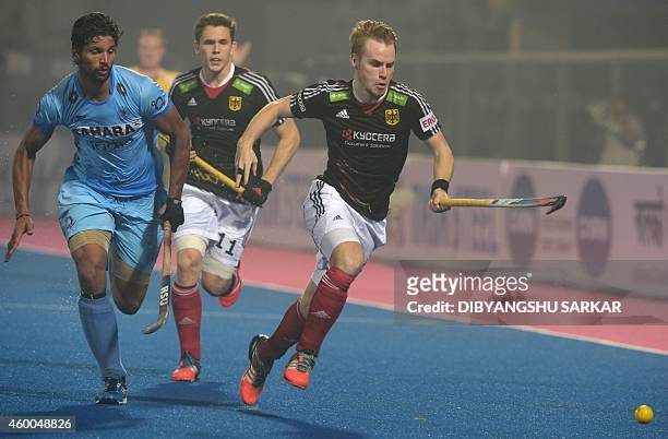 Germany's hockey player Christopher Ruhr is challenged by Indian hockey player Dharamvir Singh during their Hero Hockey Champions Trophy 2014 match...