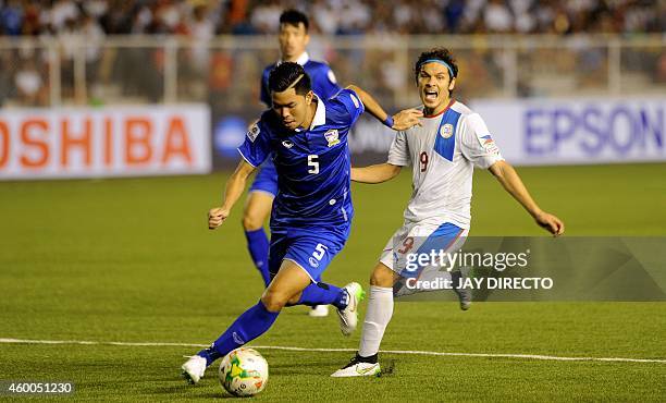 Thailand's Suttinun Phomhuk fights for the ball with Philippines' Misagh Medina Bahadoran on December 6, 2014 during the first leg of the AFF Suzuki...