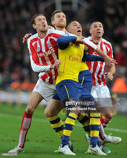 Per Mertesacker and Kieran Gibbs of Arsenal challenge Peter Crouch of Stoke during the match between Stoke City and Arsenal in the Barclays Premier...