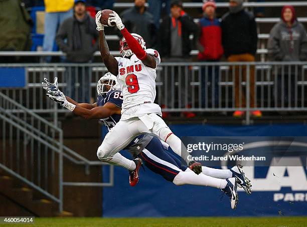 Horace Richardson of the SMU Mustangs intercepts a pass in front of Geremy Davis of the Connecticut Huskies in the second quarter during the game at...