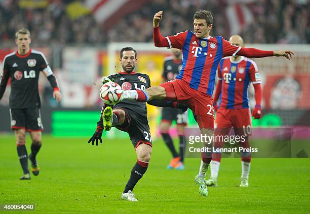 Thomas Mueller of Muenchen challenges Gonzalo Castro of Leverkusen during the Bundesliga match between FC Bayern Muenchen and Bayer 04 Leverkusen at...