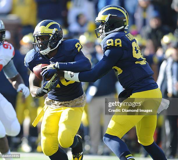 Quarterback Devin Gardner hands the ball off to running back Fitzgerald Toussaint of the Michigan Wolverines during a game against the Ohio State...