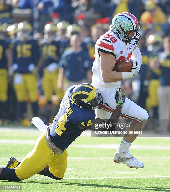 Tight end Jeff Heuerman of the Ohio State Buckeyes is tackled by defensive back Josh Furman the Michigan Wolverines during a game against the...