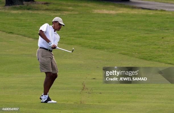 President Barack Obama takes a shot at 18th fairway as he plays golf at Mid-Pacific Country Club in Kailua, Hawaii, on January 1, 2014. The first...