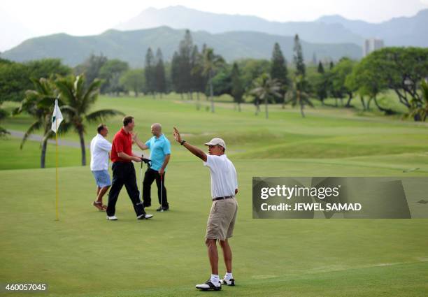 President Barack Obama waves at a crowd after putting at 18th green as he plays golf at Mid-Pacific Country Club in Kailua, Hawaii, on January 1,...