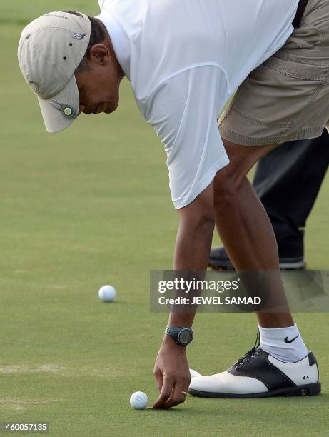 President Barack Obama marks his putt shot on the18th green while playing golf at Mid-Pacific Country Club in Kailua, Hawaii, on January 1, 2014. The...