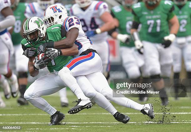 Kentrell Brice of the Louisiana Tech Bulldogs tackles Tommy Shuler of the Marshall Thundering Herd during the first quarter at Joan C. Edwards...